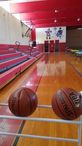 view of gym with bascketballs in foreground