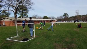 Children playing soccer on lawn