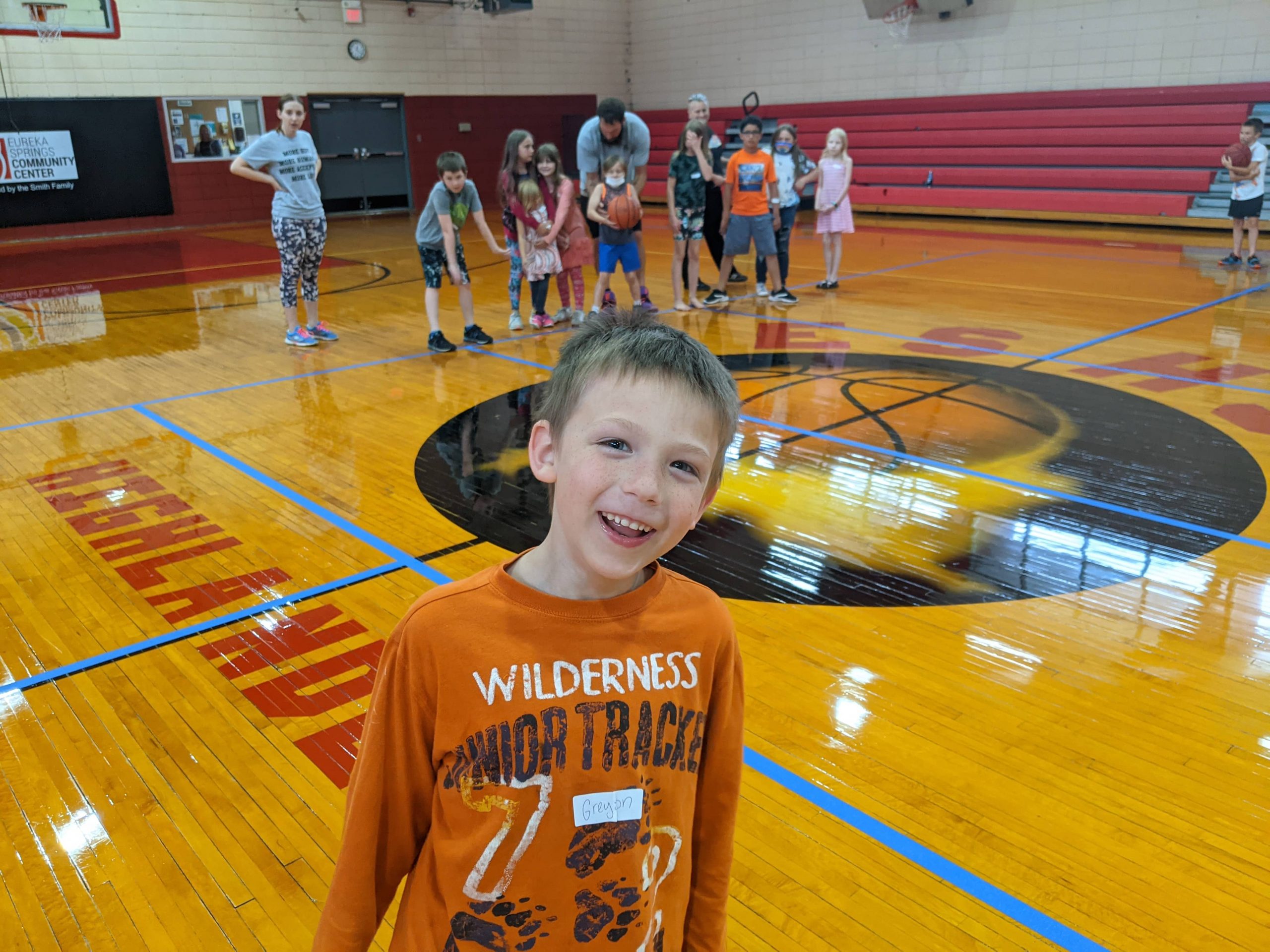 smiling boy in gym full of children