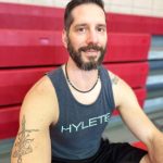 Man in black tank top with red bleachers