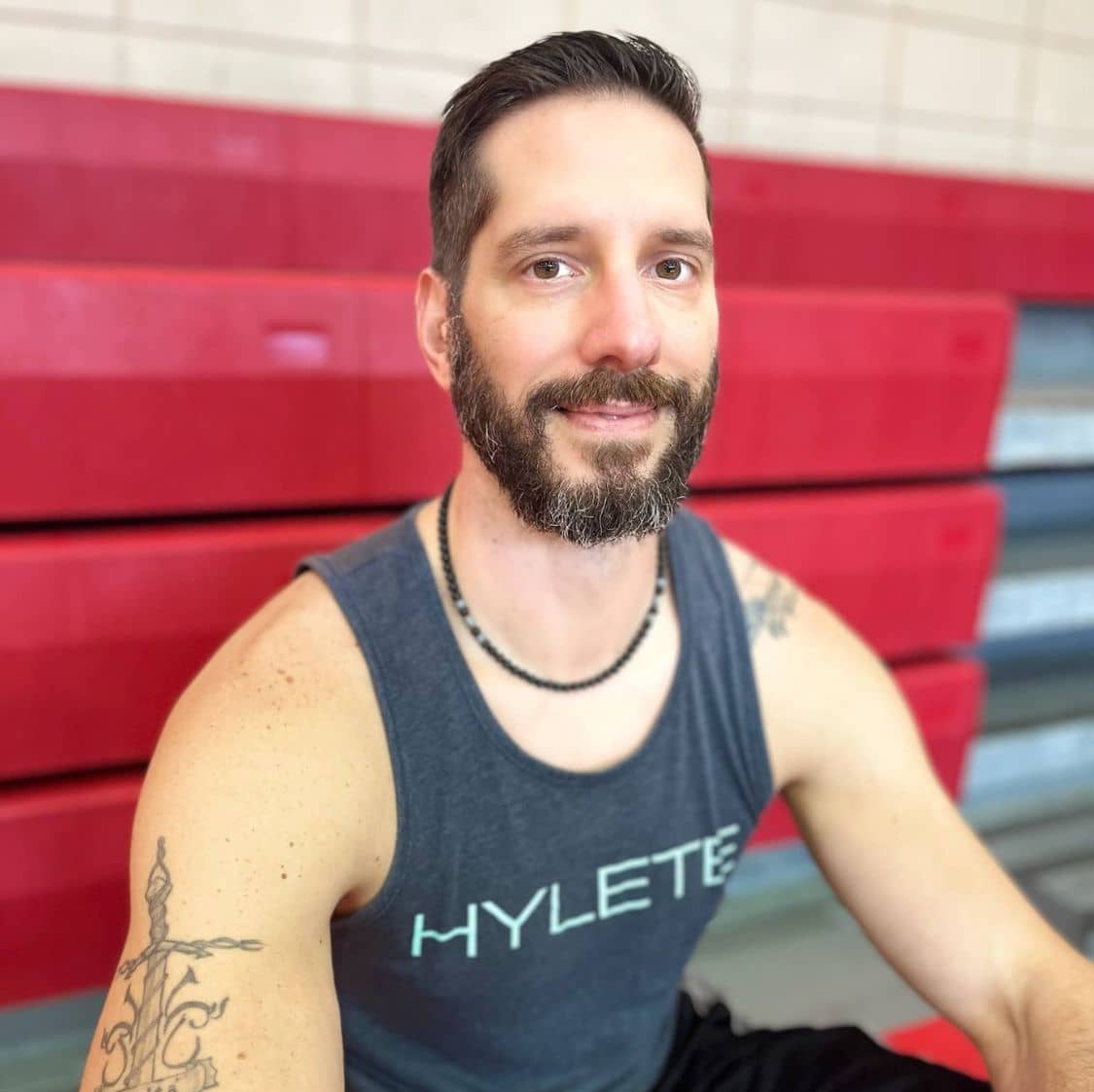 Man smiling sitting in bleachers