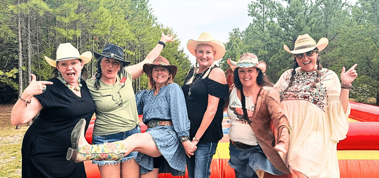 board members at a rodeo fundraiser wearing cowboy hats and smiling