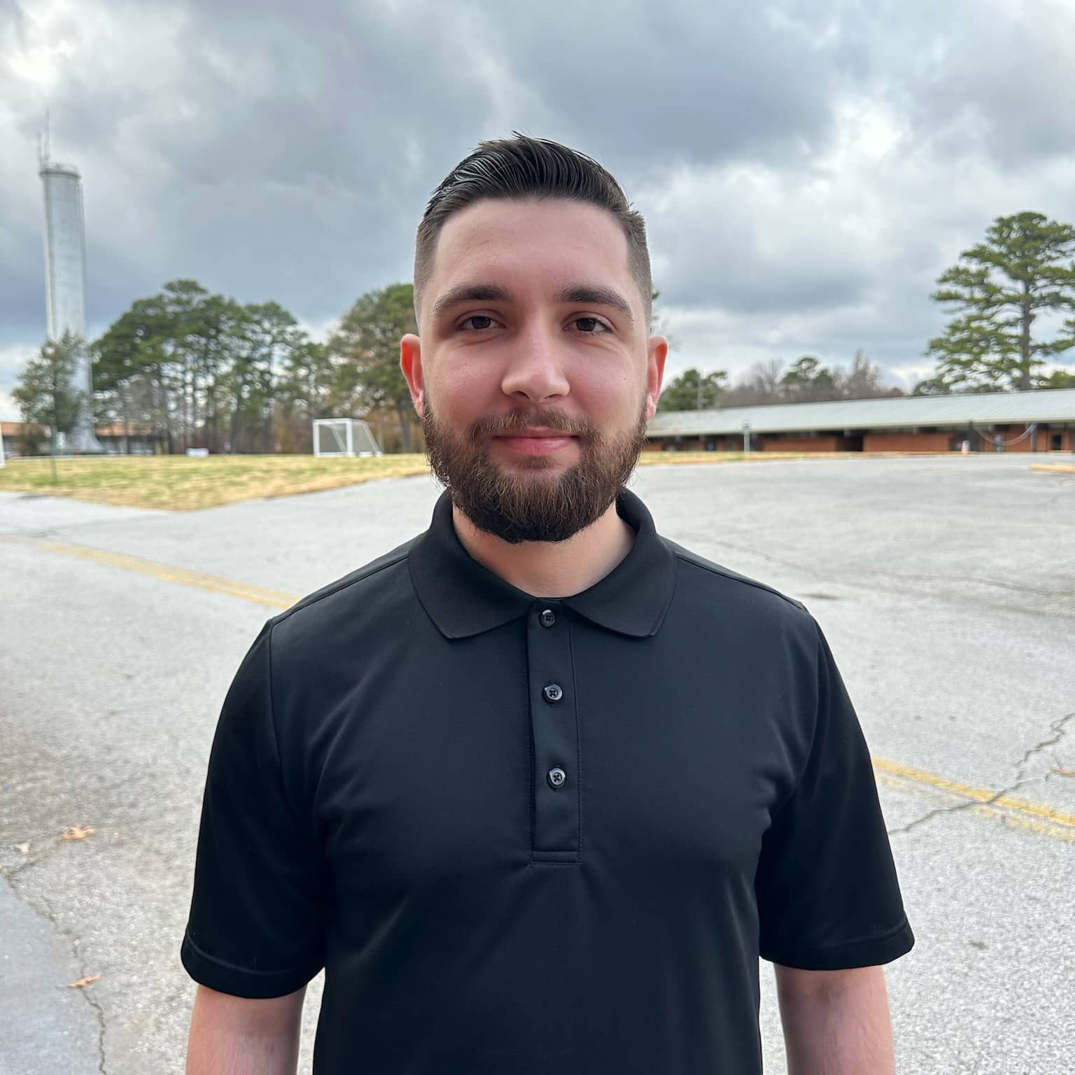 dark hair man in dark shirt outside